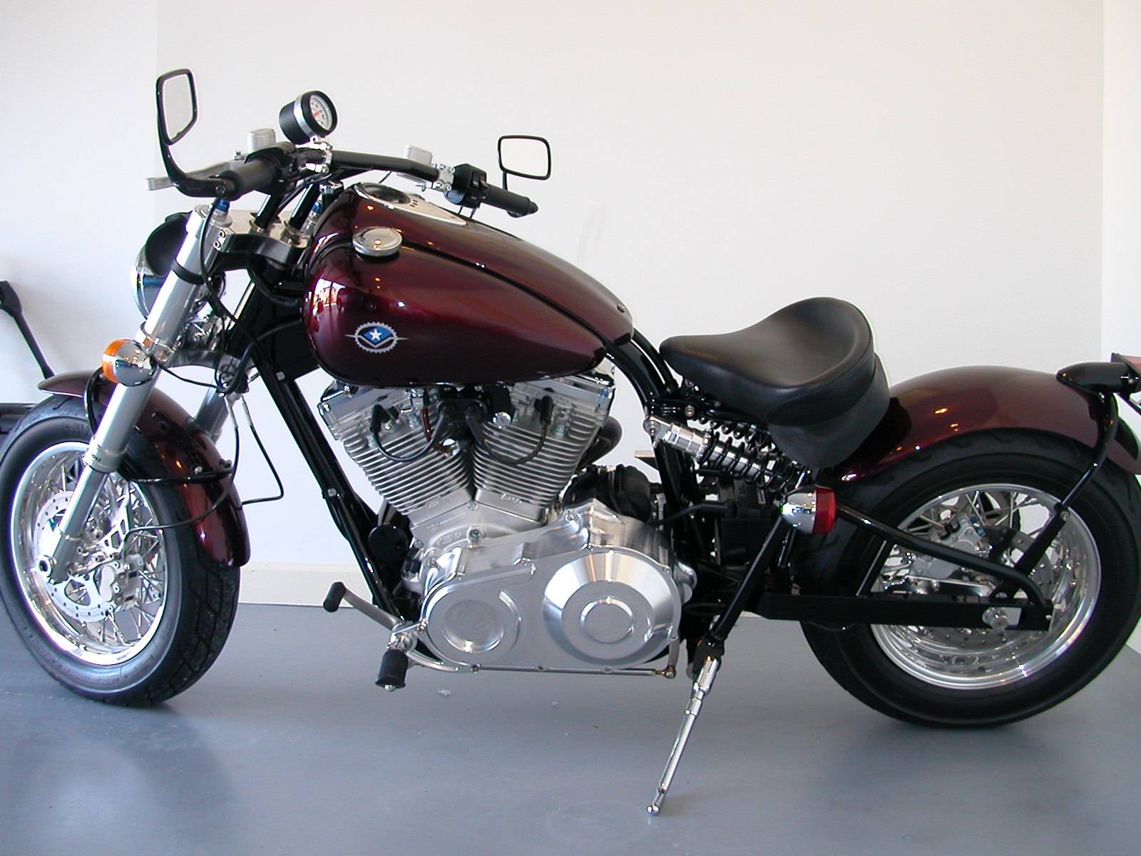 A classic red motorcycle with chrome details parked indoors.
