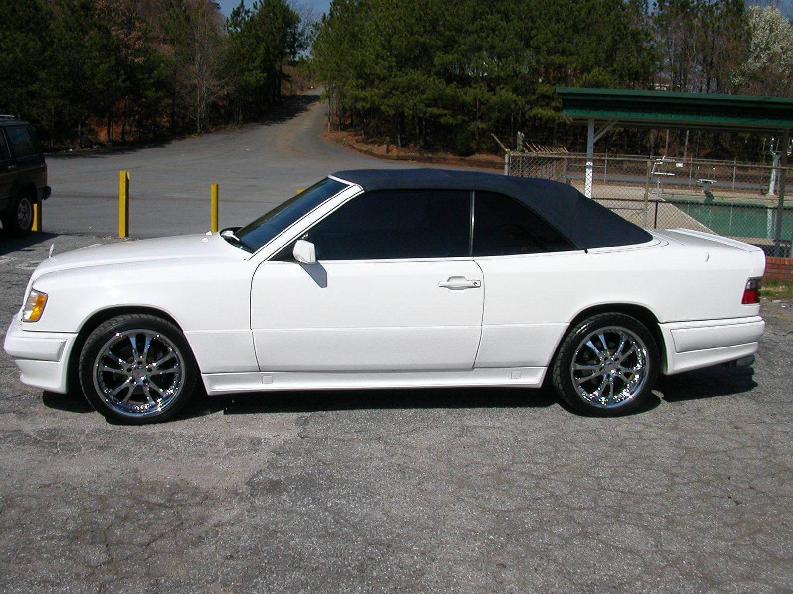 White sporty coupe parked on a sunny street with tinted windows.